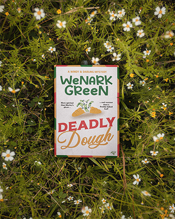 Deadly Dough paperback in front of winter fire